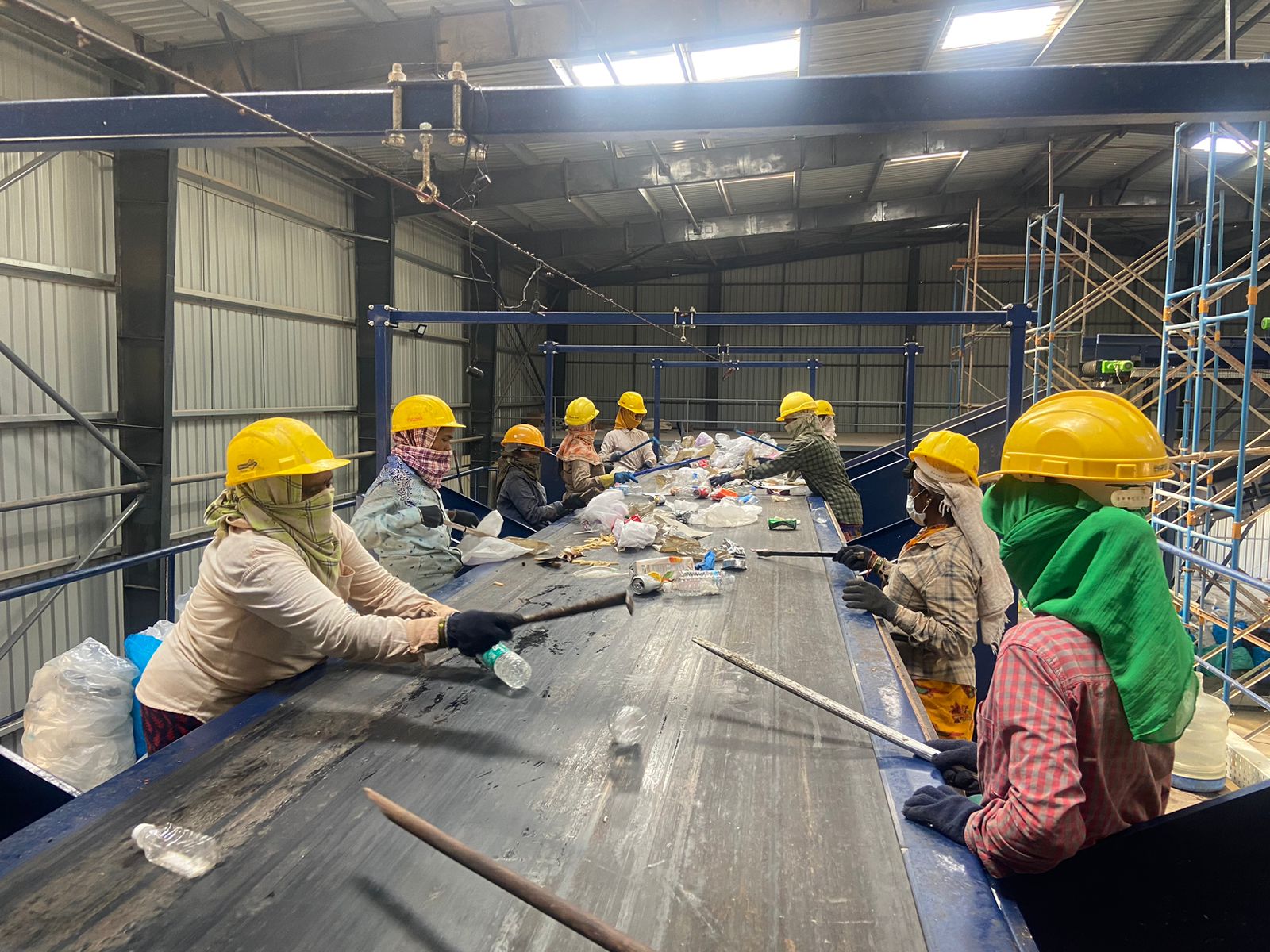 Women Workers on the mechanical sorting line, manually sorting though waste.